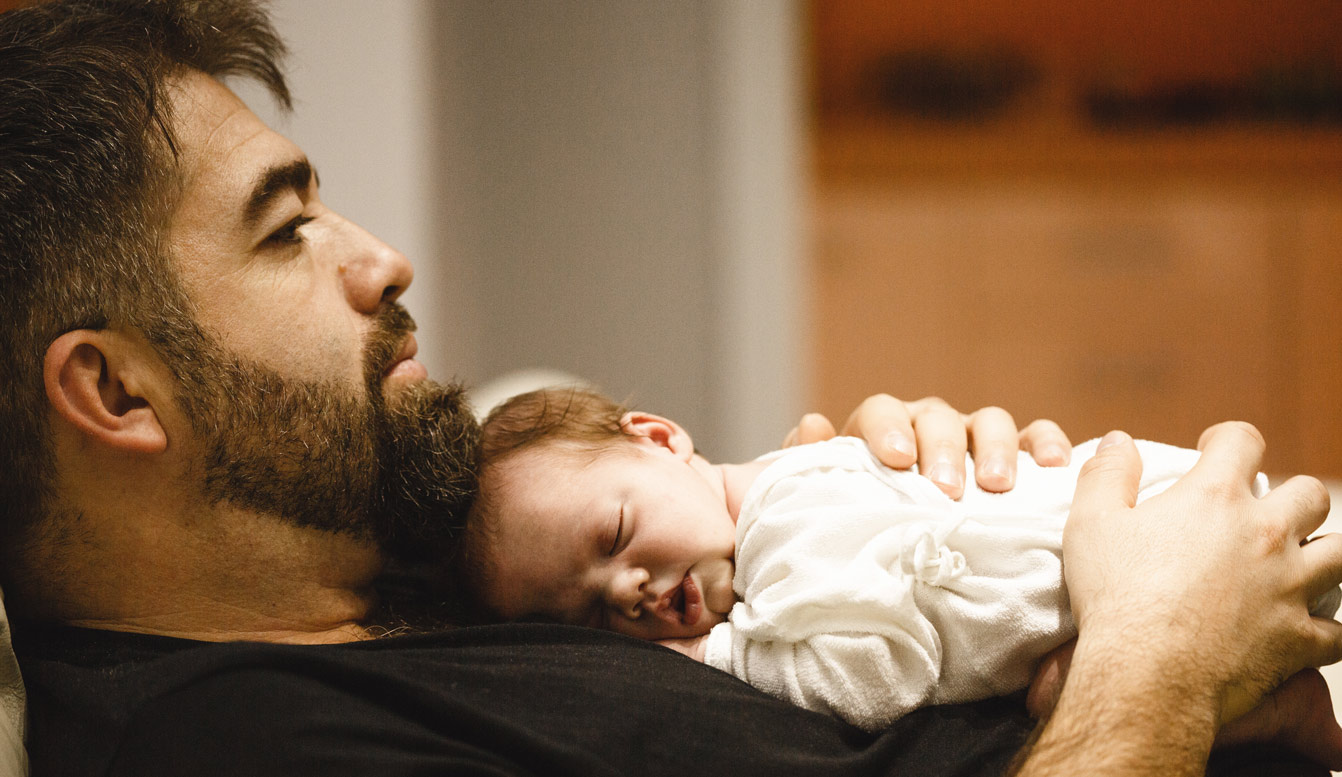 Vater hält ein schlafendes Baby an seiner Brust