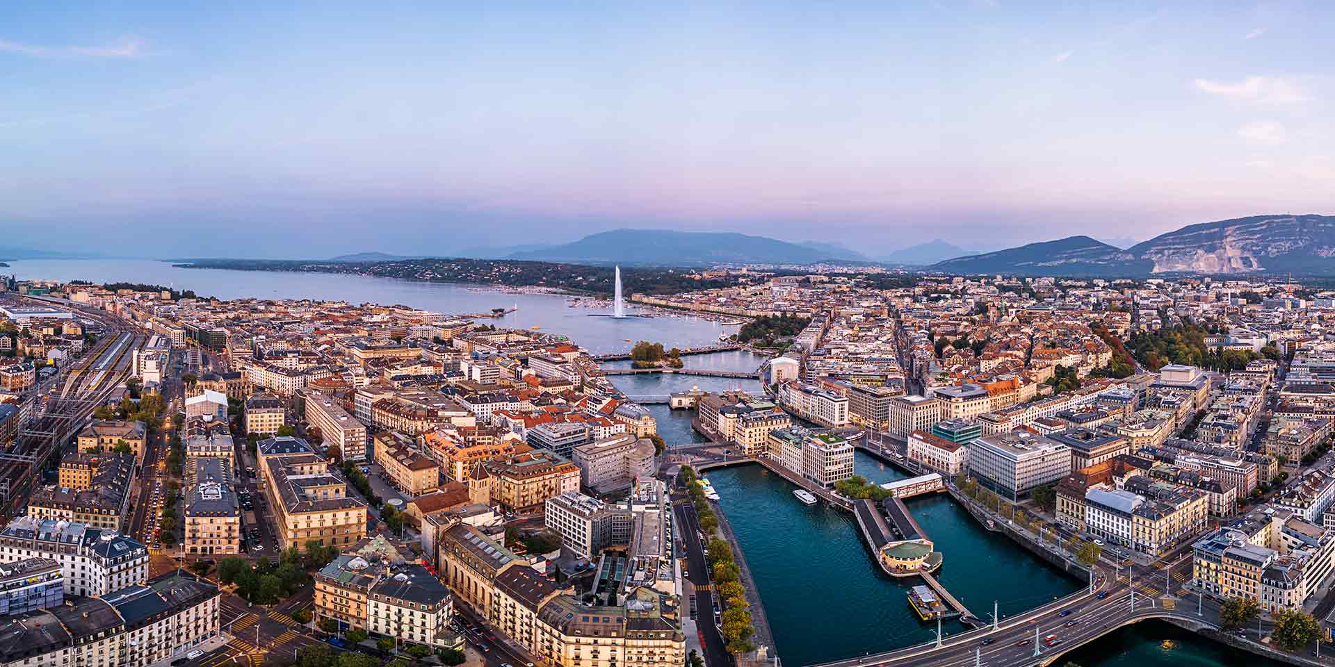 geneva, switzerland skyline view towards the jet d'eau fountain in lake geneva at twilight.