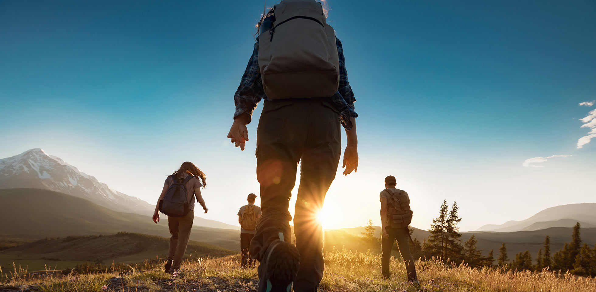 groupe de sportifs marchant dans les montagnes au coucher du soleil avec des sacs à dos. montagnes de l'altaï, sibérie, russie. tourisme