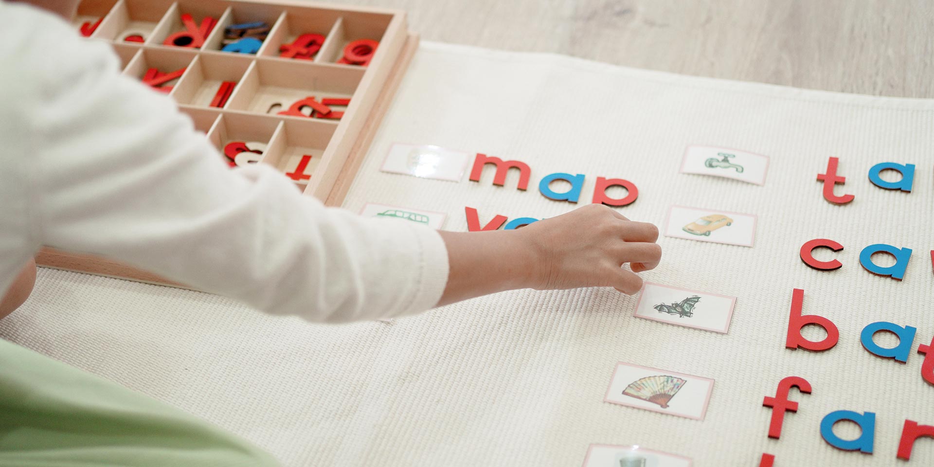 elementary girl learning rds and phonetic spelling using moveable alphabet in montessori education school and homeschooling