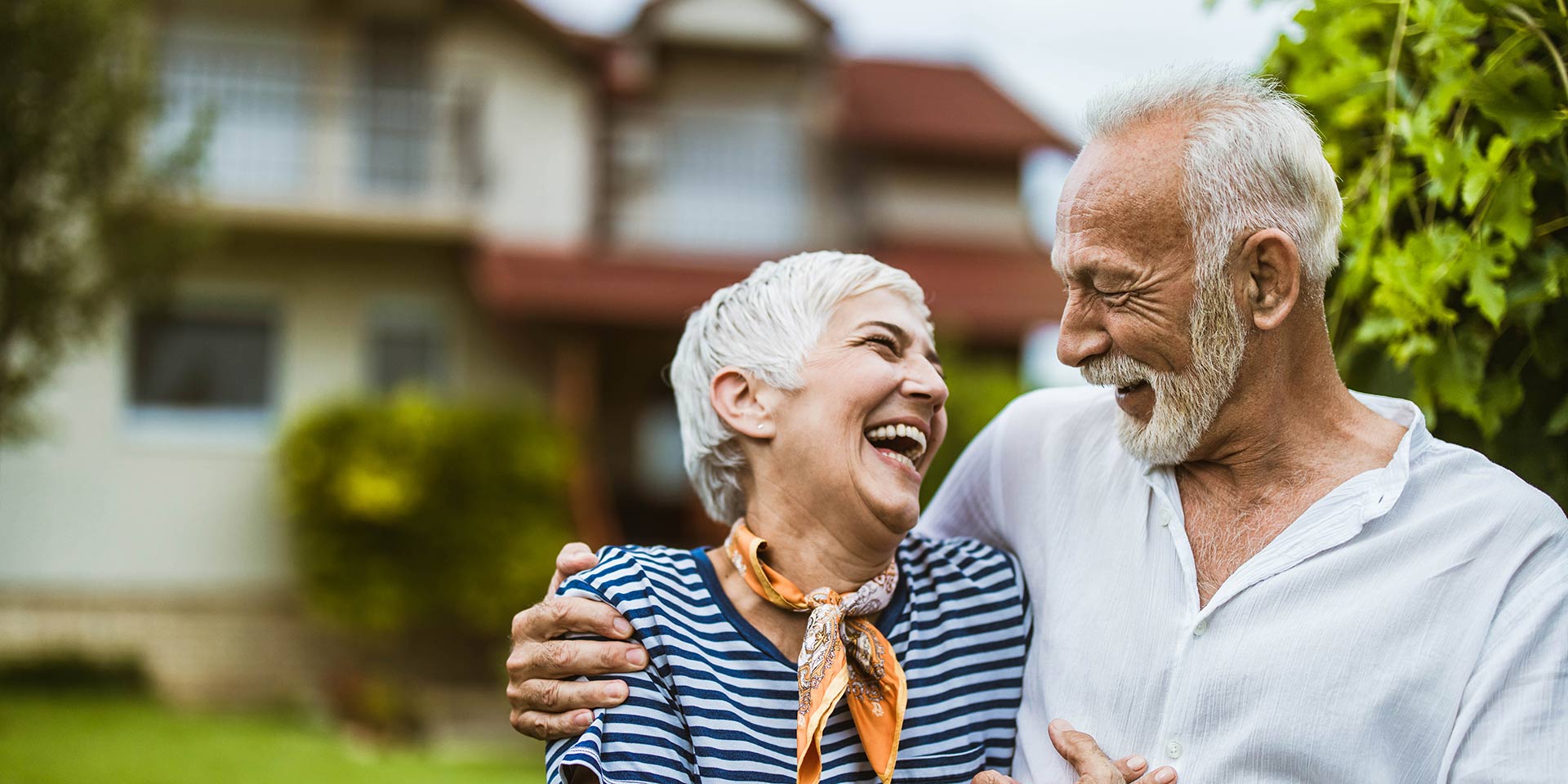 cheerful mature couple communicating while walking embraced in the backyard. copy space.