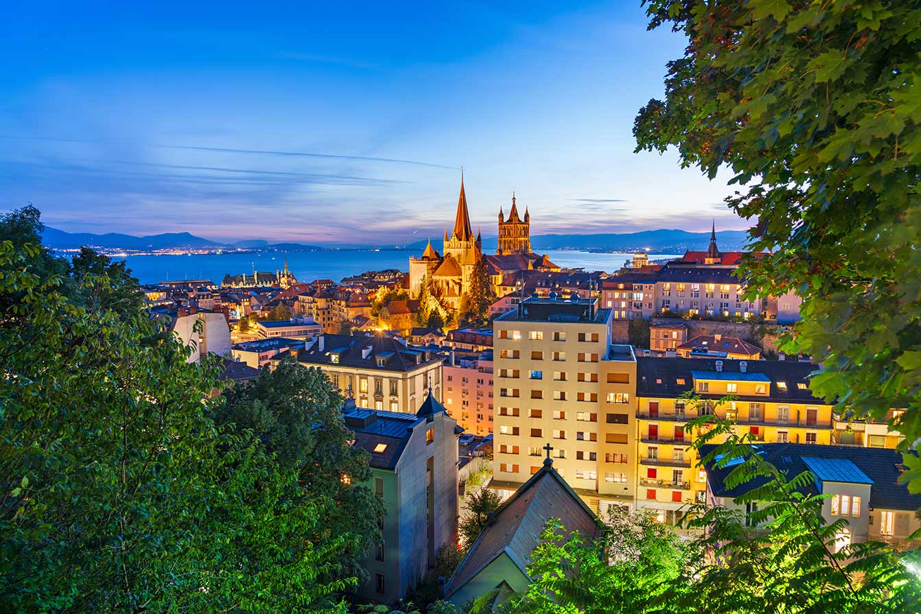 Lausanne, Switzerland historic cathedral and downtown cityscape at blue hour.