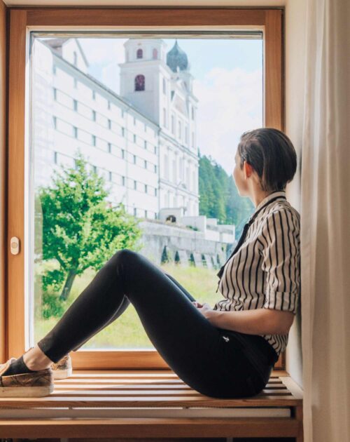 Junge Frau schaut aus dem Fenster des Gymnasiums & Internats Kloster Disentis