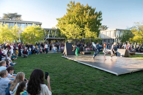 Performance de Urban Move Academy devant le public et le bâtiment principal de la Deutsche Schule Genf.
