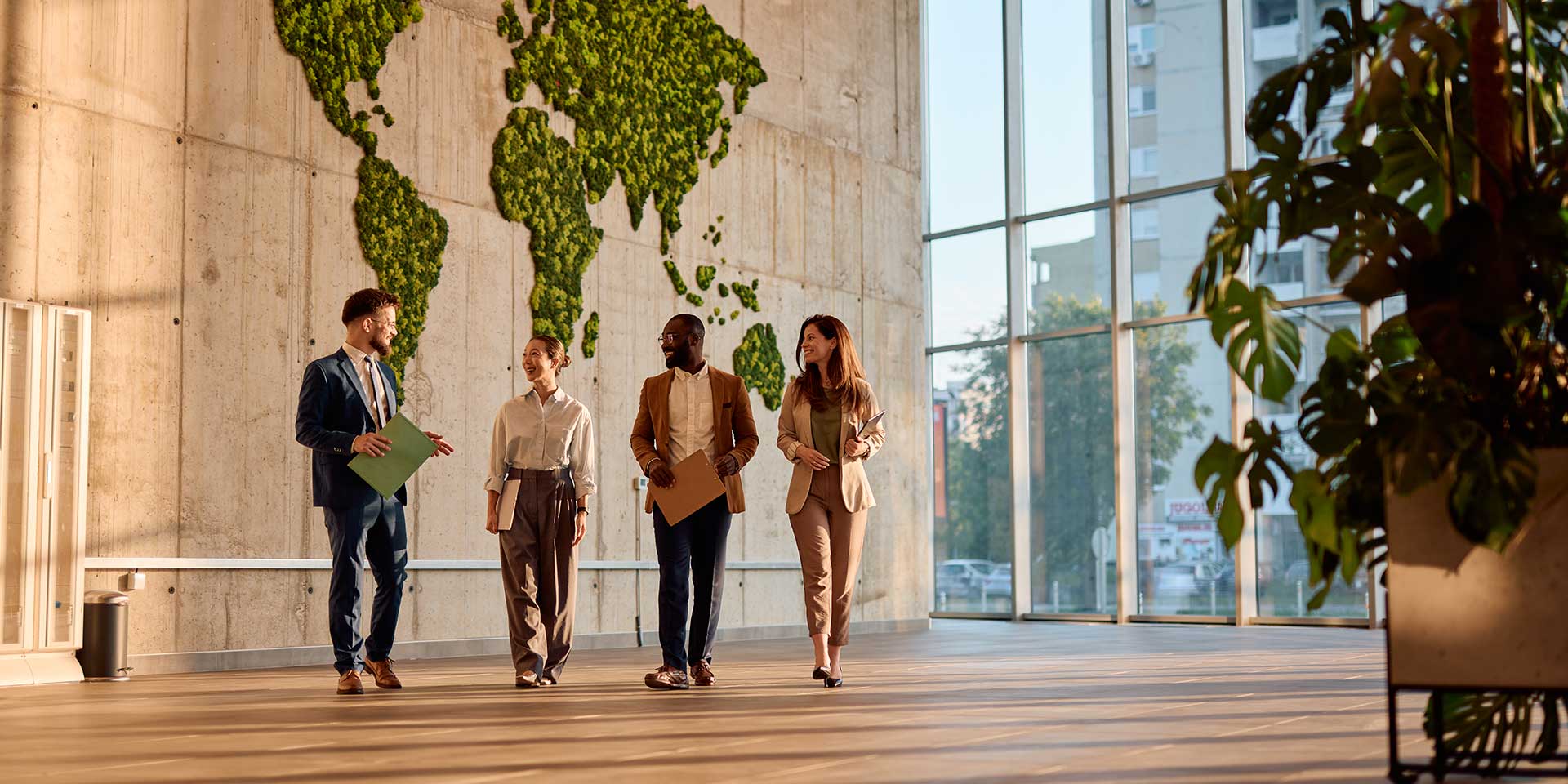 businesspeople walking and talking in a mon office with a green rld map